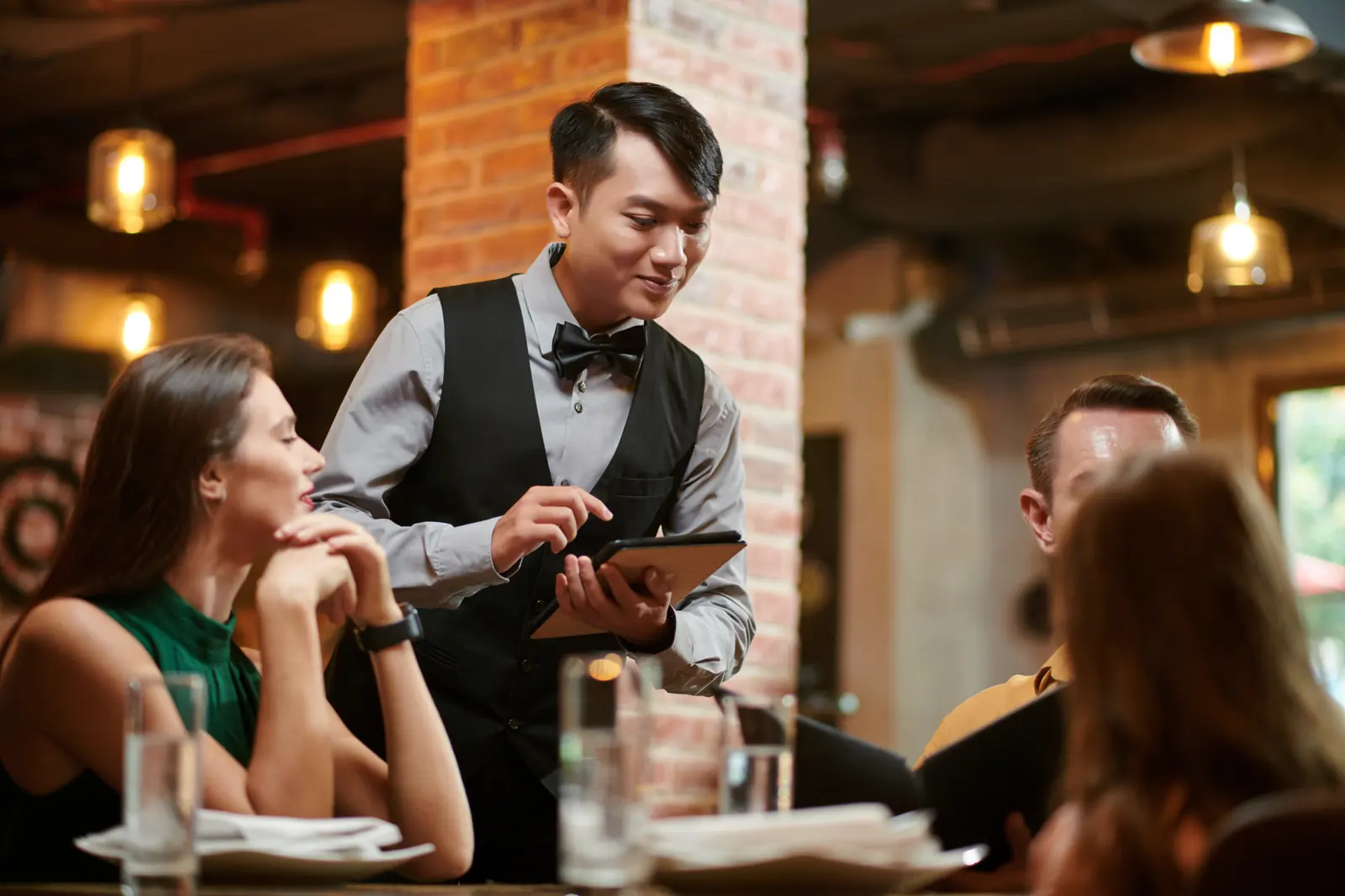 A waiter takes an order on a tablet
